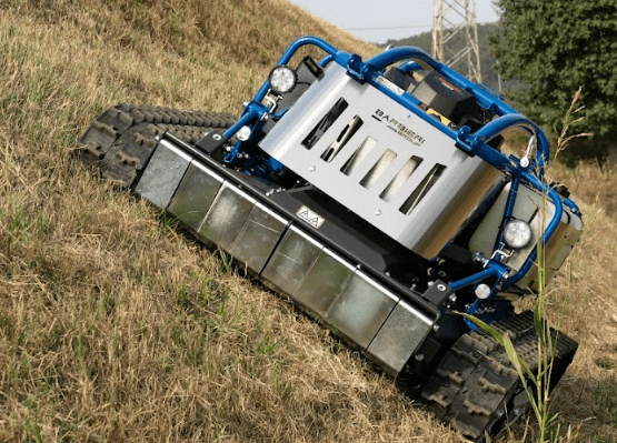 草地の斜面で稼働するクローラー式ラジコン草刈機